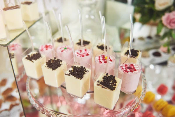 Wedding reception dessert table with delicious decorated white cupcakes with frosting closeup