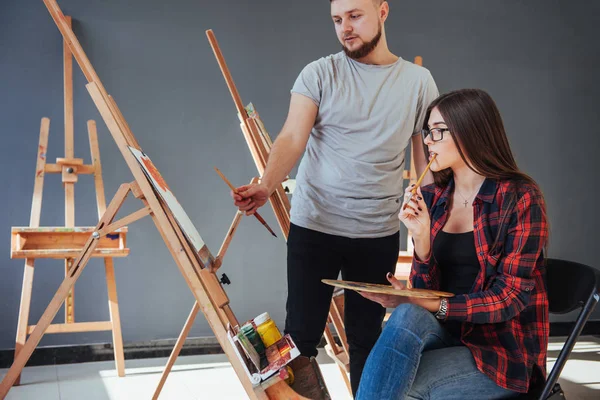 Artists paint pictures in the studio. Creative artists have designed a colorful picture painted on canvas with oil paints in the studio.