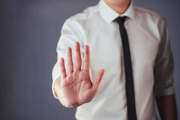 Joven Empresario Con Traje Muestra Mano Sobre Fondo Oscuro Aislado — Foto de Stock