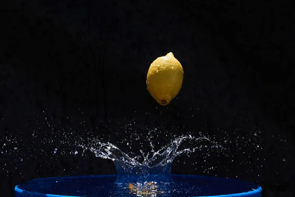 Soczysty Żółty Cytryna Spada Wody Czarnym Tle — Zdjęcie stockowe