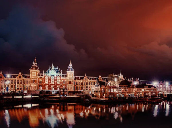 阿姆斯特丹美丽的夜晚 运河中靠近水面的建筑物和船只夜间照明 戏剧化的天空 — 图库照片