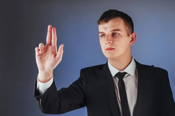 Joven Empresario Con Traje Muestra Mano Sobre Fondo Oscuro Aislado —  Fotos de Stock