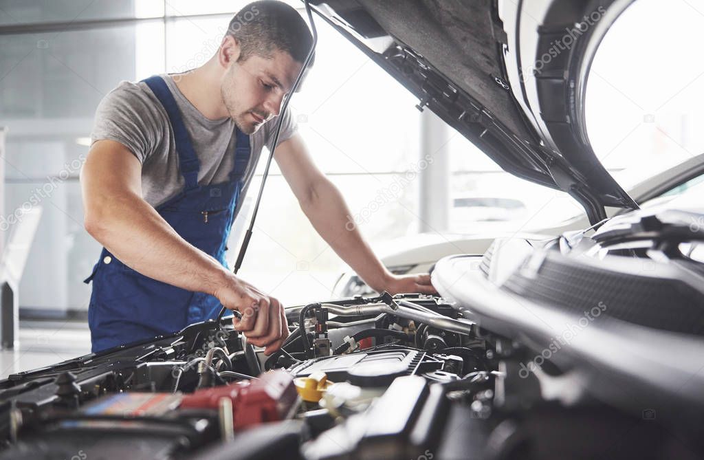 Auto mechanic working in garage. Repair service.