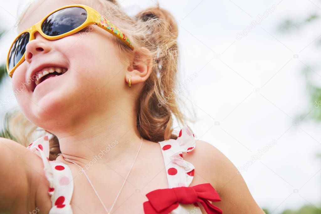 happy baby girl in a summer sunglasses.