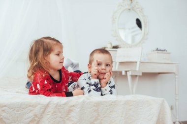Yatakta oynayan yumuşak pijamalı bir çocuk. İyi ışık stüdyosunda
