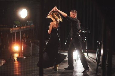 Karanlık odada ışığın altında yetenekli dansçılar gösteri yapıyor. İlk aşk, tutku, zarafet sanatı. Sevgililer Günü.