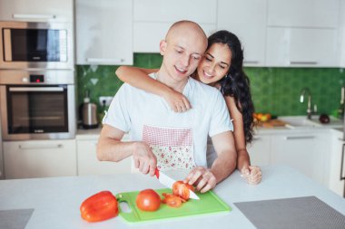 Genç ve güzel bir çift mutfakta sebze öğütüyor.