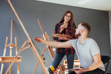 Yaratıcı sanatçılar, stüdyoda yağlı boya ile tuvale boyanmış renkli bir tablo tasarladılar..