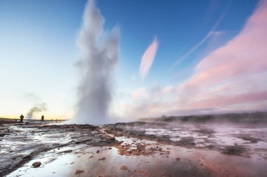 İzlanda'daki fantastik günbatımı Strokkur şofben erüpsiyon. Harika renkler.