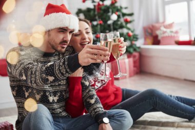 Kadeh kaldırıyorum. İki kişi yerde oturup yeni yılı kutluyor..