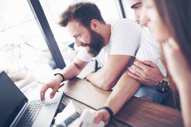 Aletleri ve dizüstü bilgisayarı olan bir grup genç beyin fırtınası düzenleyip birbirleriyle iletişim kuruyorlar. Genç bir iş geliştirme konsepti.