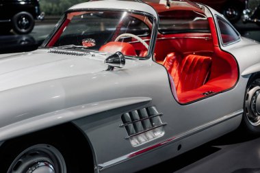 Kırmızı araba kuaförü olan beyaz bir arabanın ön tarafı..