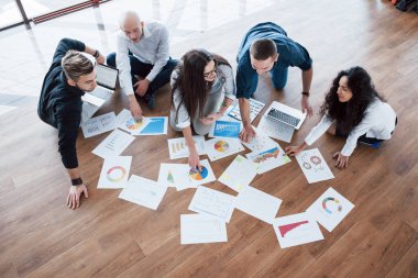 Birlikte plan yapma stratejisi. İşletme ekibi kağıtlara bakıyor ve yönetici bir fikre işaret ediyor. İşbirliği kurumsal başarı. Tasarım çizimi. Takım çalışması konsepti.
