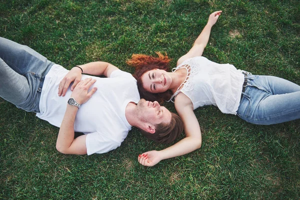 一对快乐的夫妇躺在草地上 年轻人在户外 幸福与和谐 — 图库照片
