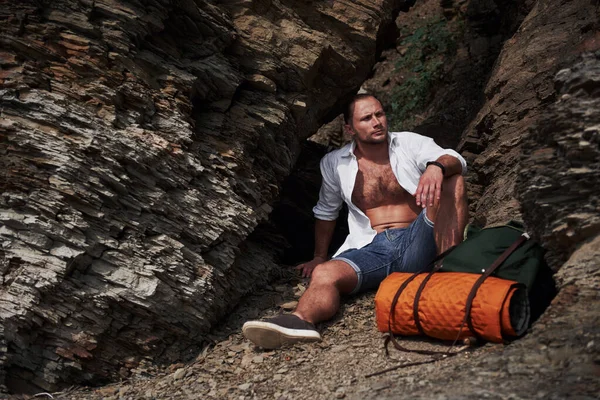 穏やかな夏の日没の間に岩塊でリラックスしたバックパック付きの若い男性ハイカー 旅行ライフスタイルアドベンチャー休暇のコンセプト — ストック写真