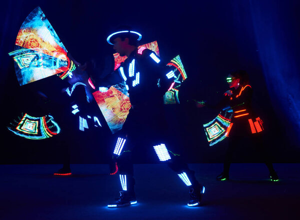 Laser show performance, dancers in led suits with LED lamp, very beautiful night club performance, party.