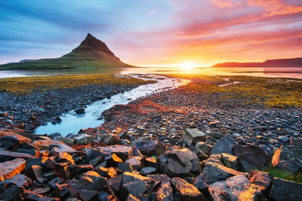 The picturesque sunset over landscapes and waterfalls. Kirkjufell mountain. Iceland.