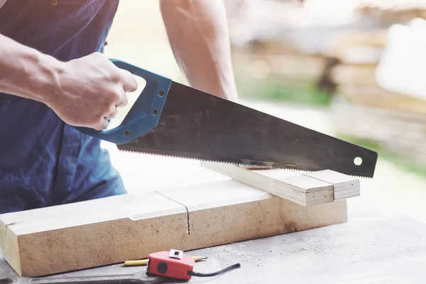 Beautiful strong hand joiner saws a wooden board