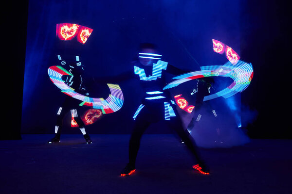 Laser show performance, dancers in led suits with LED lamp, very beautiful night club performance, party.