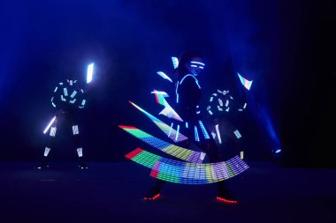 Laser show performance, dancers in led suits with LED lamp, very beautiful night club performance, party.