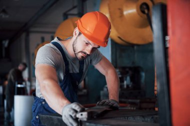 Başlık takmış deneyimli bir operatör. Metal endüstrisi konsepti profesyonel mühendis metal işçisi imalat atölyesinde Cnc değirmen makine merkezi işletiyor.