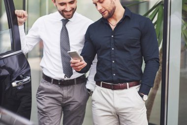 Ofisin yanında duran iki mutlu, kendinden emin genç iş adamı..