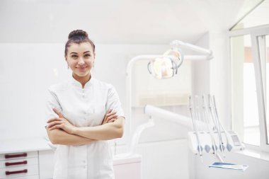 Tıbbi geçmişinde aletleri olan mutlu genç bir dişçi. Stomatoloji ve sağlık konsepti.