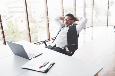 Zor bir gün ortaya çıktı. Genç işadamı, temiz odada sandalyeye oturup gözlerini kapatırken dinleniyor..