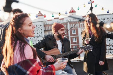 Müzik insanları birleştirir. Genç arkadaşlar çatıda alkol ve gitarla parti veriyorlar..