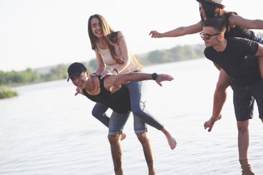 Mutlu arkadaşlar sahilde eğlenir - yaz tatilinde genç insanlar.