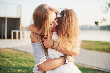 Çekici, mutlu, genç bir anne. Parktaki çimlerin üzerinde tatlı kızıyla yatıyor.