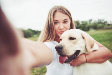 Çekici genç kadın labrador açık havada. Kadın ile köpek labrador geri almak yeşil çimenlerin üzerinde.
