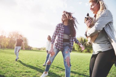 Gündelik kıyafetli bir grup arkadaş açık havada futbol oynuyor. İnsanlar eğleniyor ve eğleniyor. Aktif dinlenme ve manzaralı gün batımı.