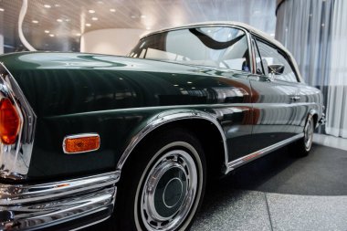 Farları görebiliyorum. Kürsüde duran yeşil renkli arabanın sol tarafının zemin katındaki fotoğrafı..