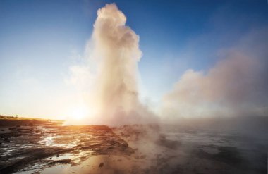 İzlanda'daki fantastik günbatımı Strokkur şofben erüpsiyon. Harika renkler.