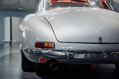 Arkadan bir fotoğraf. Beyaz tarihi pahalı retro araba kürsüde duruyor..