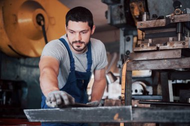 Başlık takmış deneyimli bir operatör. Metal endüstrisi konsepti profesyonel mühendis metal işçisi imalat atölyesinde Cnc değirmen makine merkezi işletiyor.