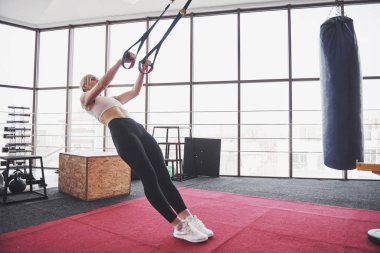 İtme yapıyor kadınlar trx fitness askıları kavramı egzersiz sağlıklı yaşam spor salonunda silahlarla eğitim ups.