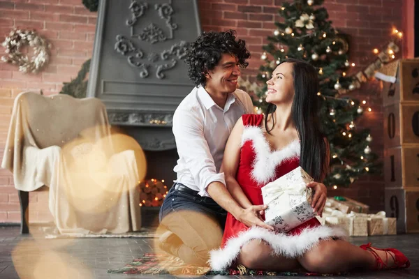 愛をもって見つめ合うのです クリスマスツリーと暖炉の後ろに飾られた部屋で新年を祝う美しいカップル — ストック写真