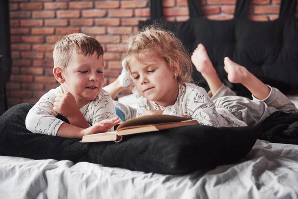 Zwei Kinder Liegen Auf Einem Großen Bett Und Lesen Ein — Stockfoto