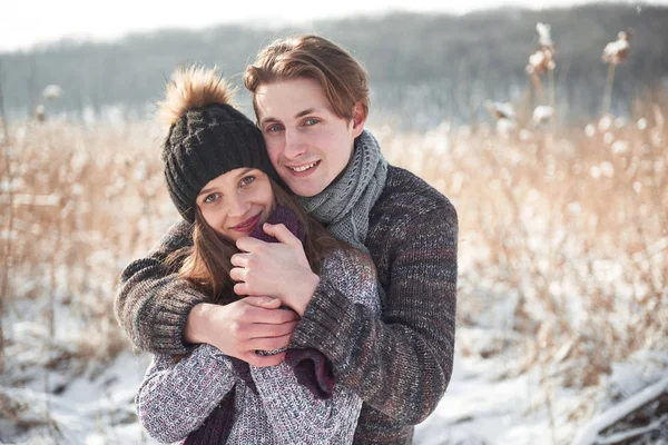 Happy couple playful together during winter holidays vacation outside in snow park.