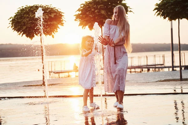 Madre Con Bebé Cerca Fuente Atardecer — Foto de Stock