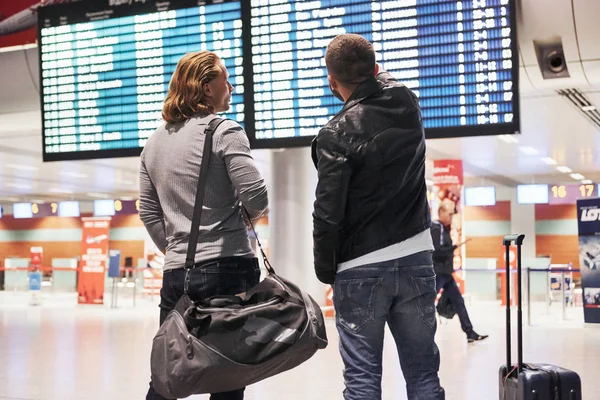 Man Shows Time Plane Arrival Photo Two Comrades Situating Airport — 스톡 사진