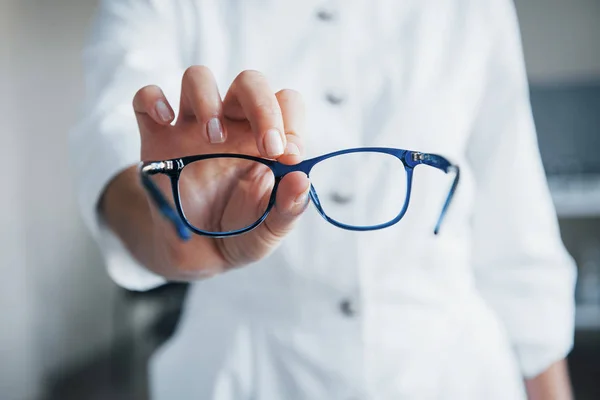 Médica Feminina Segurando Óculos Azuis Uma Mão — Fotografia de Stock