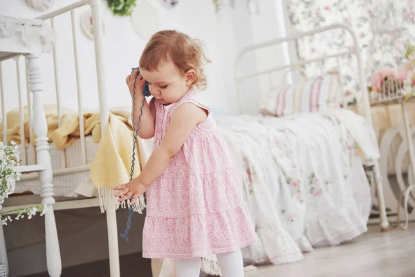 幼少期のコンセプト カラフルな糸で可愛いドレス遊びで赤ちゃんの女の子 白ヴィンテージ子供部屋 — ストック写真