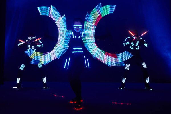 Laser show performance, dancers in led suits with LED lamp, very beautiful night club performance, party.