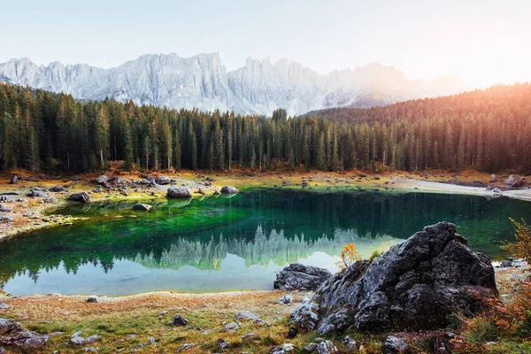 Little mere. Autumn landscape with clear lake, fir forest and majestic mountains.