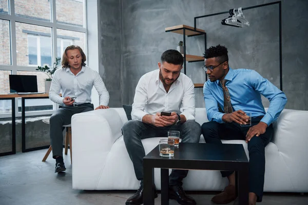 Sentada Sofá Bebiendo Whisky Discutiendo Grupo Trabajadores Oficina Multirraciales Ropa — Foto de Stock