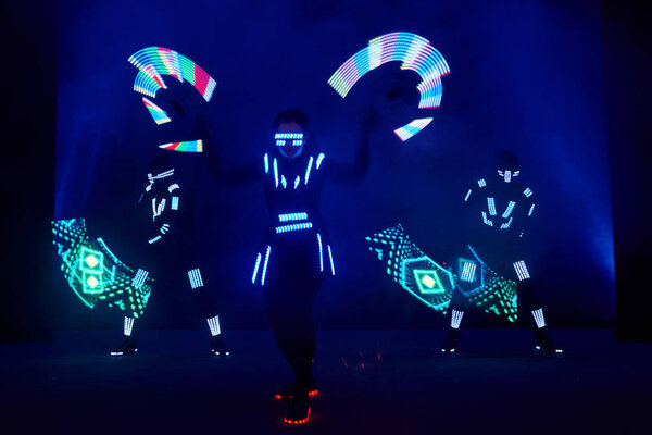 Laser show performance, dancers in led suits with LED lamp, very beautiful night club performance, party.