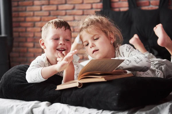 Two Children Lie Large Bed Read Interesting Book Dressed Same — Stock Photo, Image